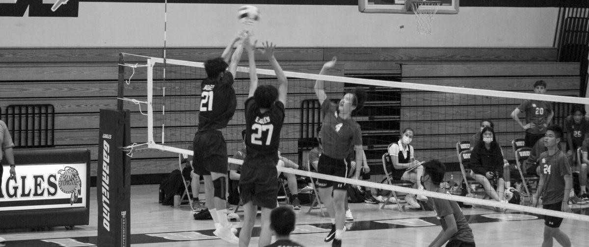 QUICK HITS  Senior Johnny Taing and junior Nathan Huang jump up to hit a volleyball over the net in a game against San Marino High School at the big gym, as a San Marino player reaches to intercept it.