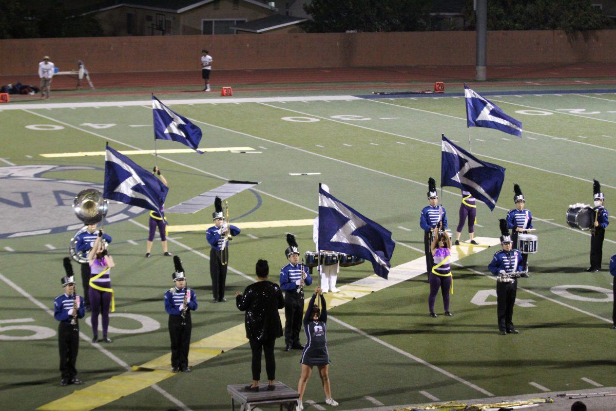 SKY HIGH Color guard points their flags to the sky during a half-time performance.