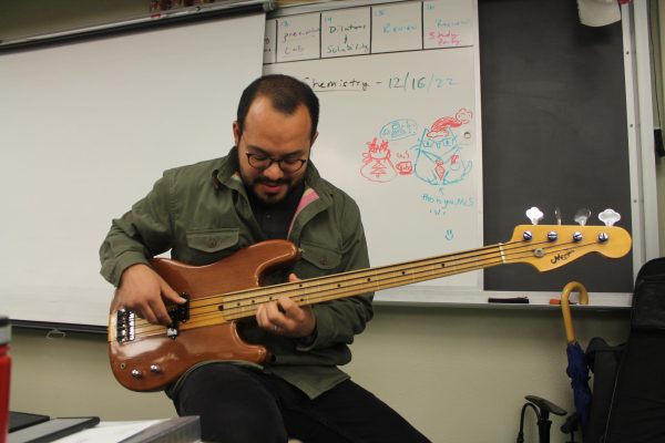 MAKING MUSIC Joseph Salcedo strums his bass in Room B201.