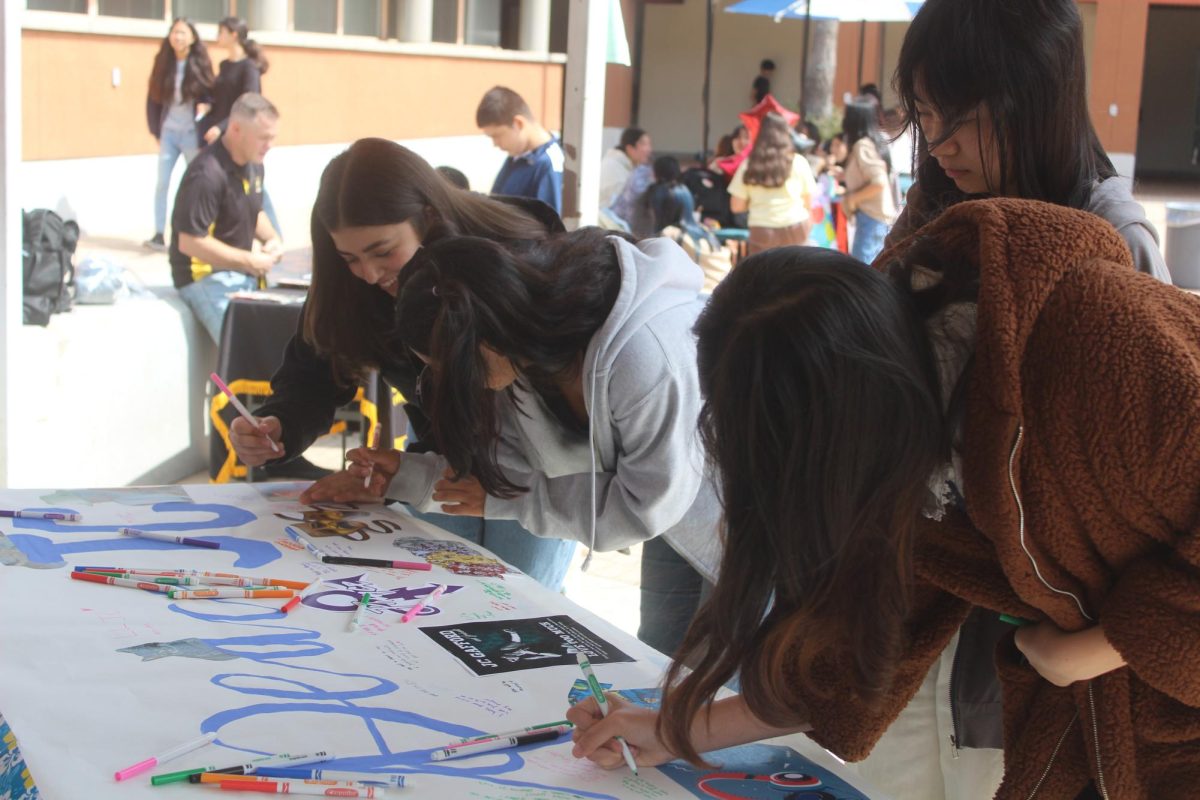 In Memoriam  Students sign a poster in remembrance of drama teacher JC Gafford. 