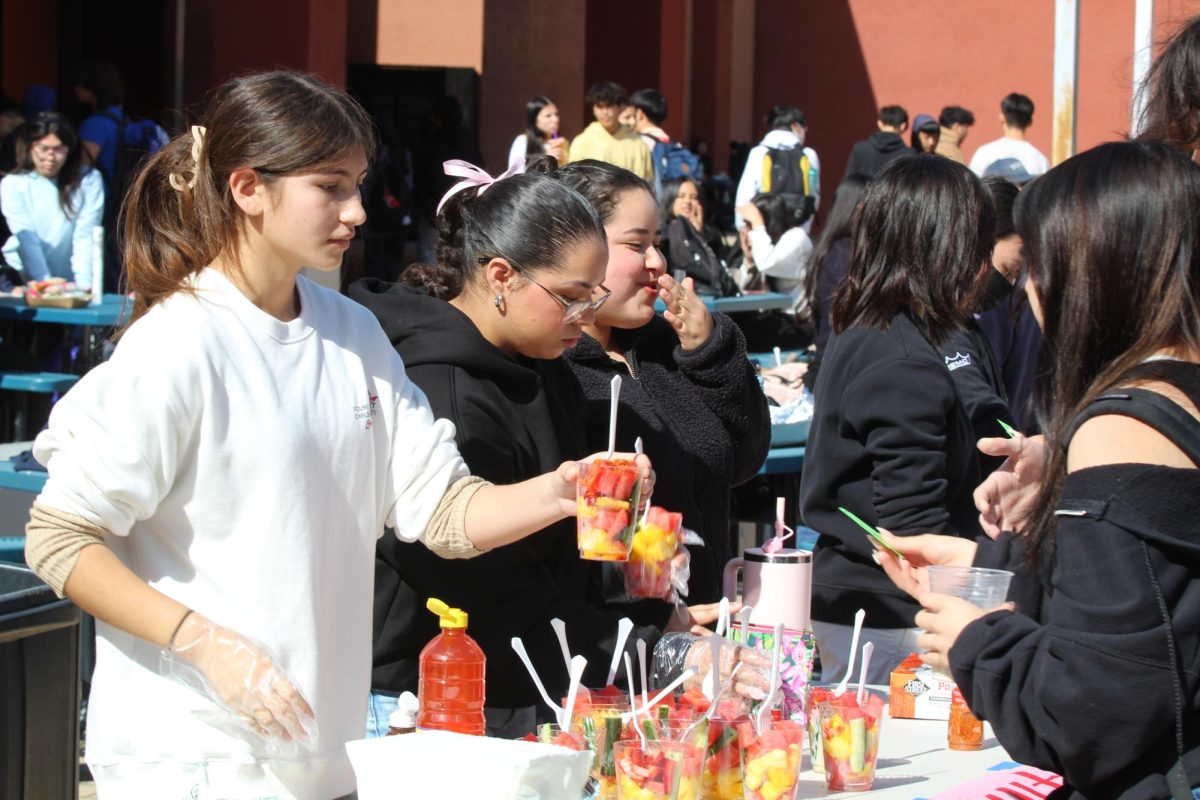  Michaela Lau (10), Desiree Cardenas (12), and Melanie Olmedo (12) serve up some refreshing fruits with diverse topping options. 