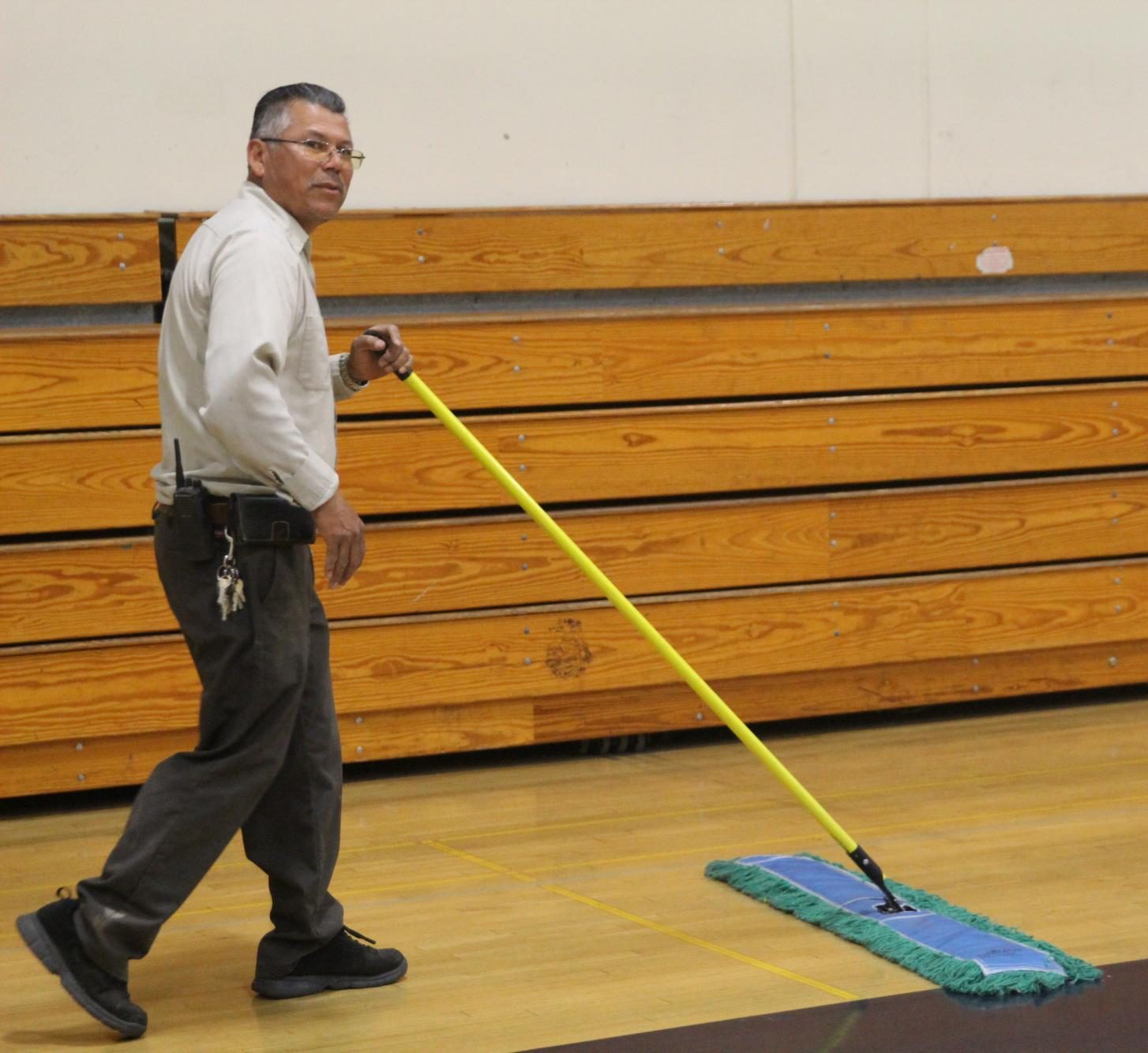 Hernandez mops the small gym floor
