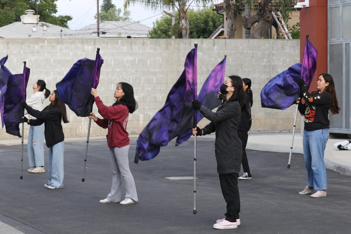 The winter guard team performs outside of the M building.