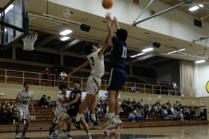 Justin Chia, junior point guard, making a contested jump shot.