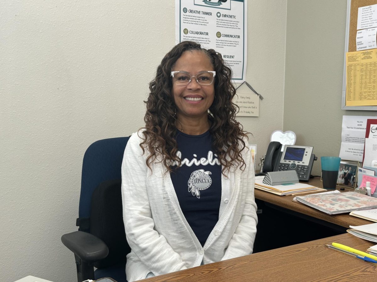 DR. HUFF - Dr. Rose Huff sits in her office, the district "Portrait of a Graduate" poster that she strives to help all her students achieve just behind her. 