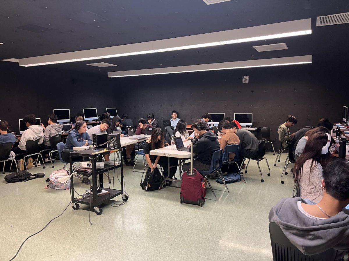 A black soundproof room hums with the sound of computers while students work on music demos for the class.