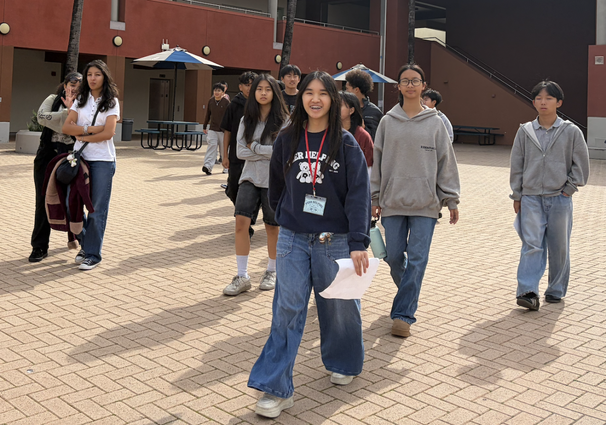 Senior Kylie Chang leads a group of students around campus.